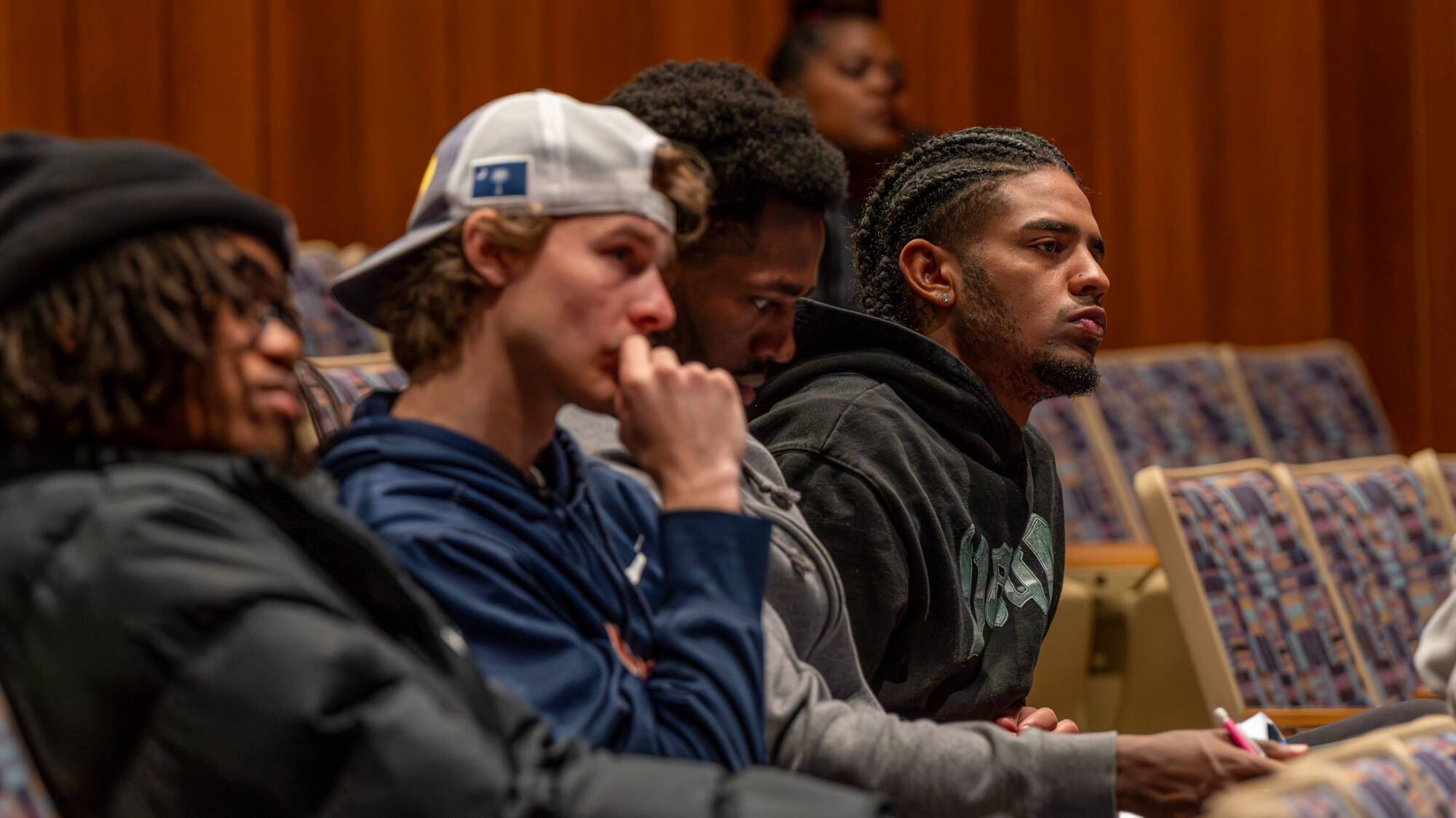 Grand Valley students Quade Johnson, Andon Grigg, Trey Diepenhorst and Malik Immoos listens as LaTosha Brown speaks at the Haas Center for Performing Arts